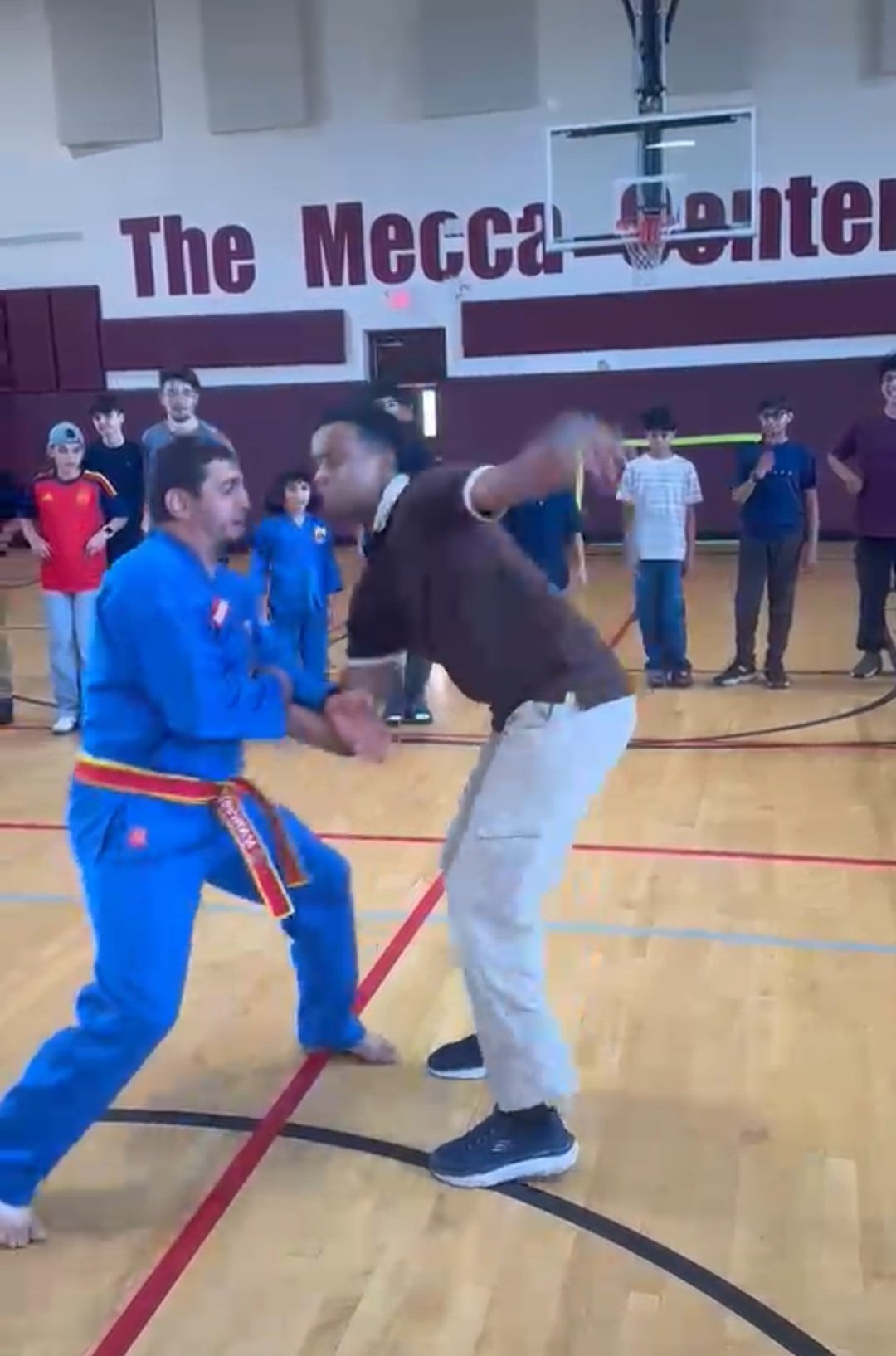 Coach Redouane demonstrating a technique with a student at Mecca Center